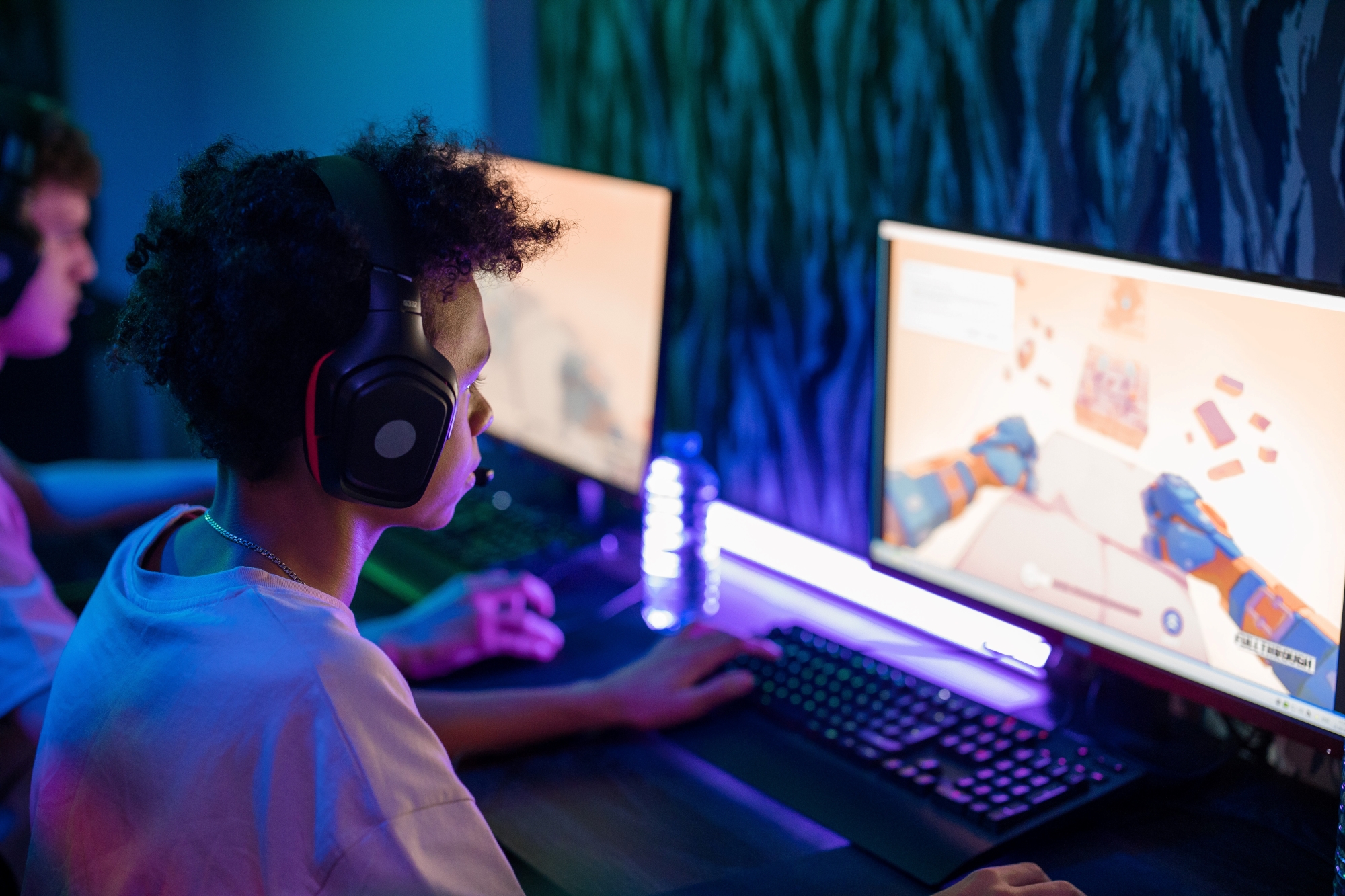 Little boy playing video games in the dark with a headset on